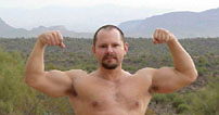 Jeff in a double bicep pose in desert
